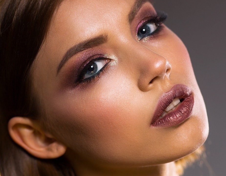 A woman with heavy makeup to give her skin a healthy glowing appearance